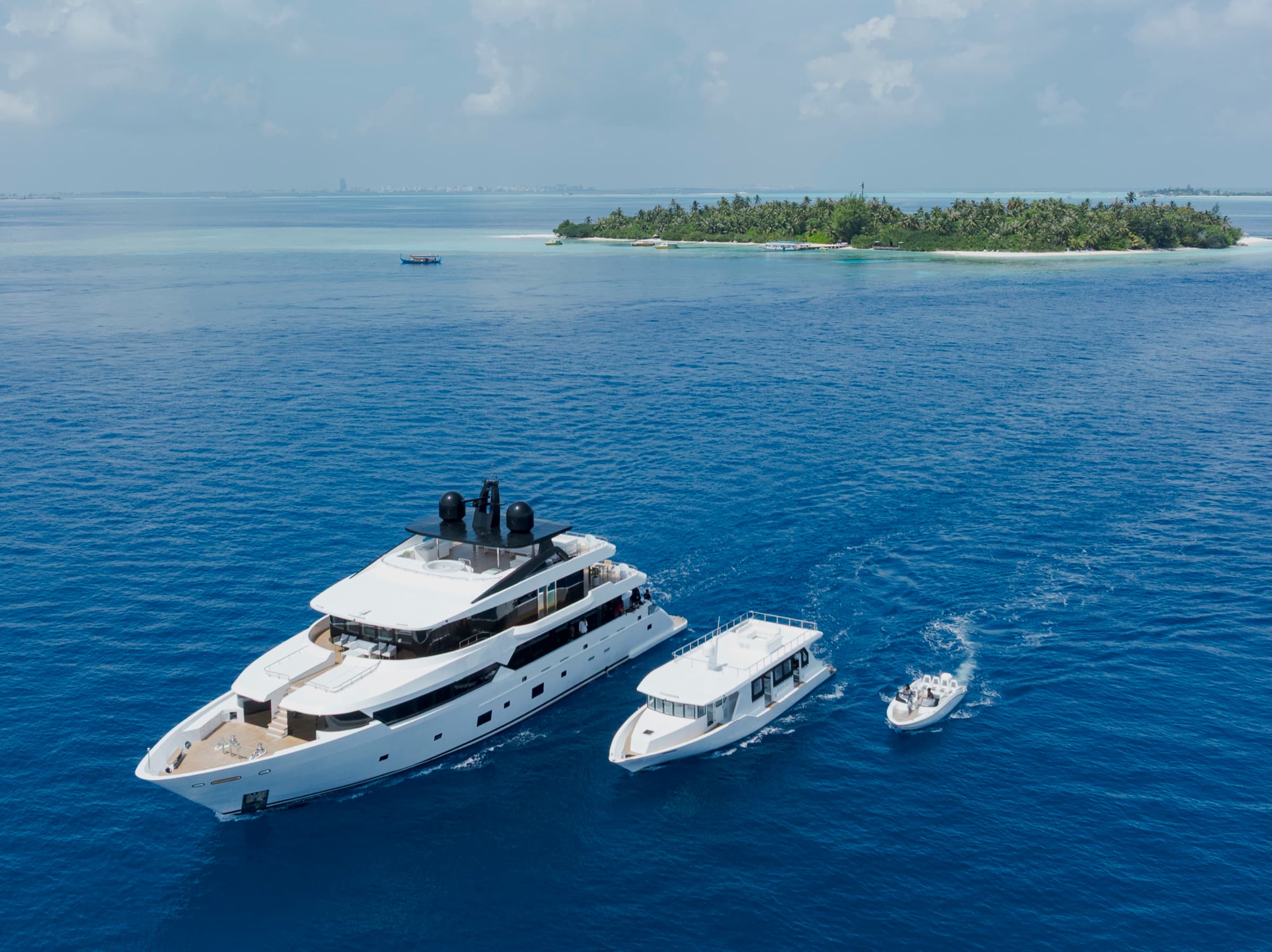 Aerial view of SERAI Ocean Dream luxury yacht with tender boats near a Maldives island